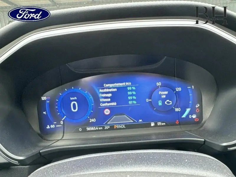Tableau de bord numérique bleu du Ford Kuga 2022 hybride, affichant vitesse, consommation et mode éco.