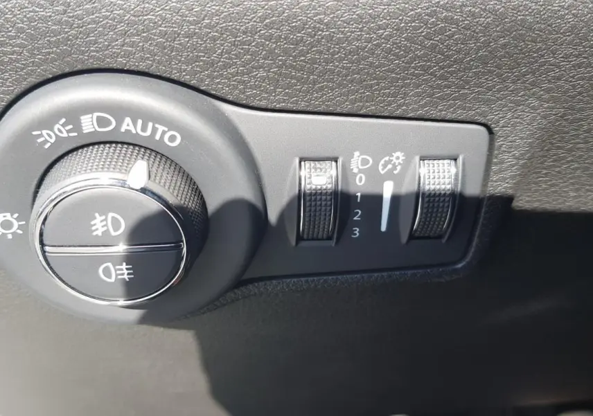 Gros plan sur la molette de réglage des phares et des feux antibrouillard du Jeep Compass blanc 2024.