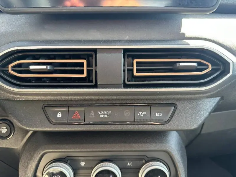 Vue rapprochée des aérateurs centraux noirs avec contours cuivrés sur le tableau de bord du Dacia Sandero Stepway 2025.