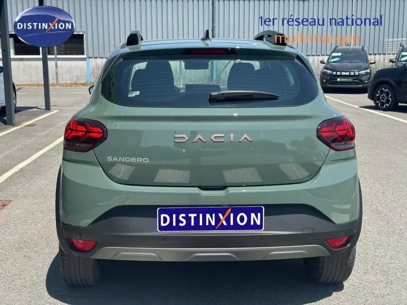Vue arrière d'une Dacia Sandero 2025 vert cèdre métallisé avec logo DACIA et feux arrière LED distinctifs.