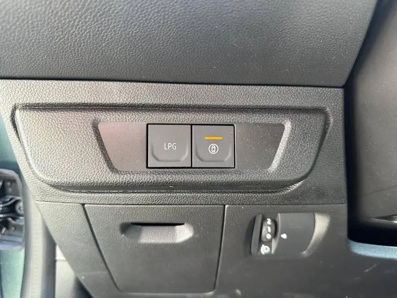 Gros plan sur les boutons LPG et verrouillage centralisé côté gauche du tableau de bord d'une Dacia Sandero 2025.