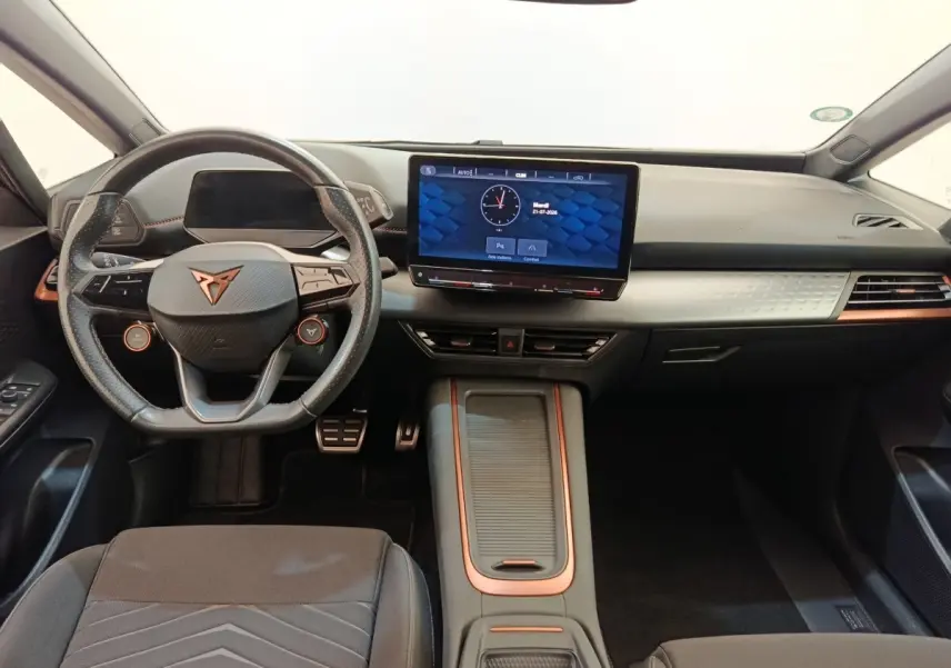 Vue intérieure avant du tableau de bord et volant cuir noir avec touches cuivre du CUPRA BORN 230ch gris foncé 2023 électrique.