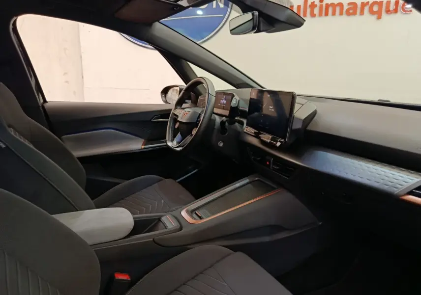 Vue intérieure côté conducteur de la CUPRA BORN 230ch gris foncé, avec tableau de bord digital et volant multifonctions cuir.