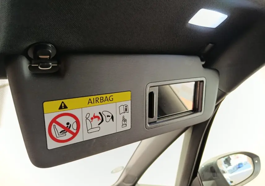 Détail du pare-soleil côté conducteur avec miroir intégré et étiquette airbag dans une CUPRA Born gris foncé 2023.