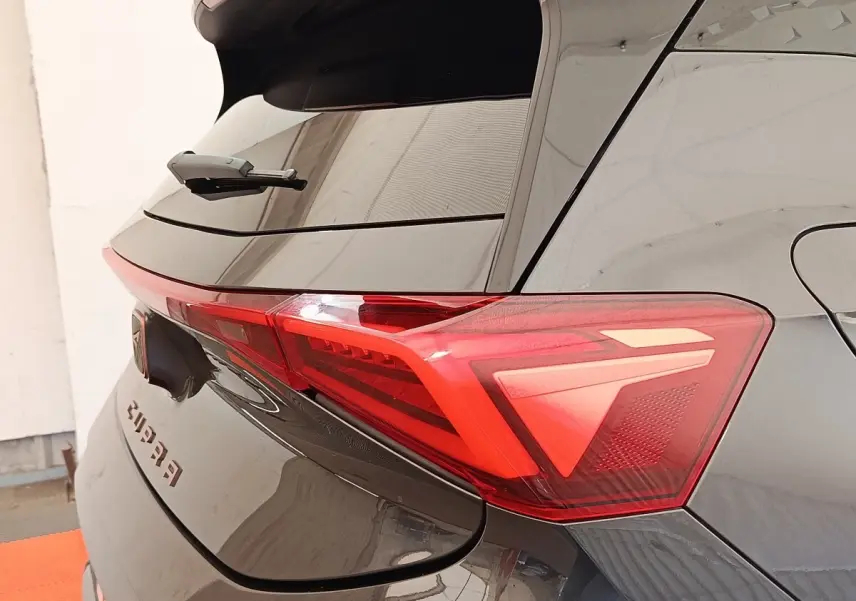 Vue arrière droite du CUPRA BORN gris foncé, mettant en valeur le feu arrière LED et le logo CUPRA sur le hayon.