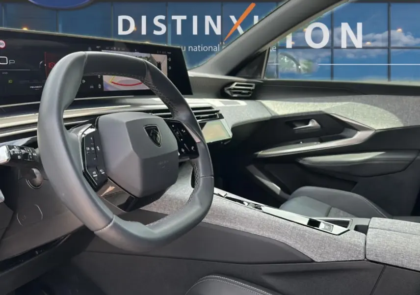 Vue intérieure côté conducteur du Peugeot 3008 1.2 hybrid 145 allure 2025 avec volant cuir et tableau de bord numérique.
