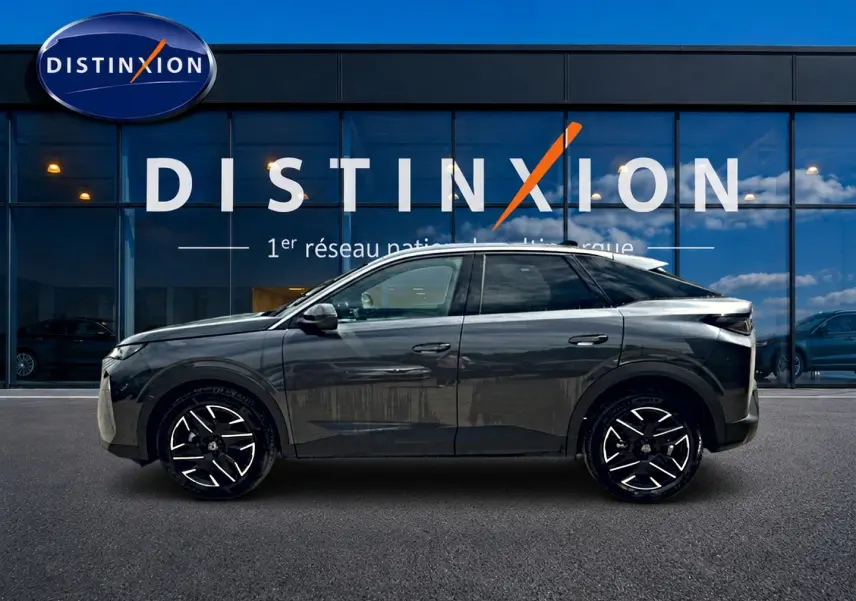 Peugeot 3008 gris titane en profil droit devant une vitrine avec logo Distinxion, jantes alu noires et blanches.