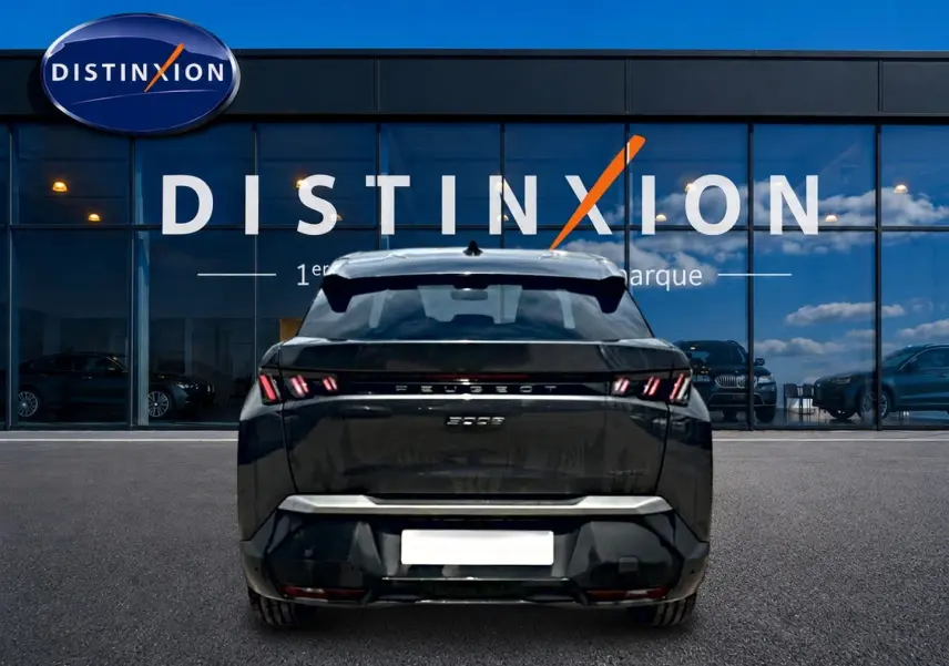 Vue arrière d'un Peugeot 3008 gris titane 2025 stationné devant une vitrine avec logo Distinxion.