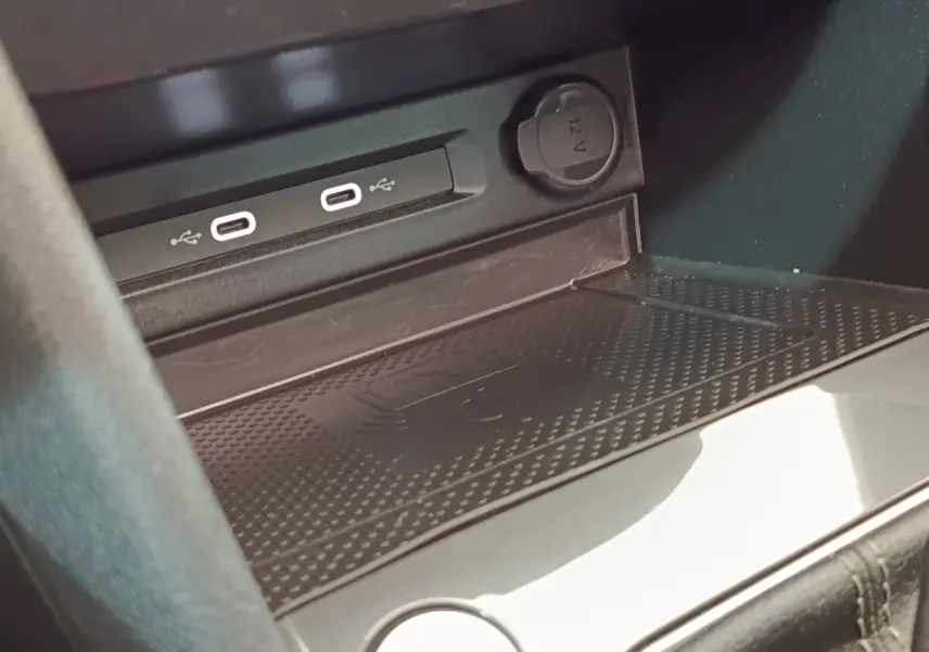 Gros plan sur la console centrale du Volkswagen Tiguan blanc, montrant les ports USB-C et prise 12V.