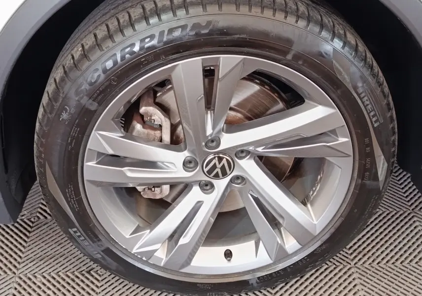 Gros plan sur la jante alliage argentée et pneu Pirelli Scorpion du Volkswagen Tiguan blanc hybride rechargeable 2023.