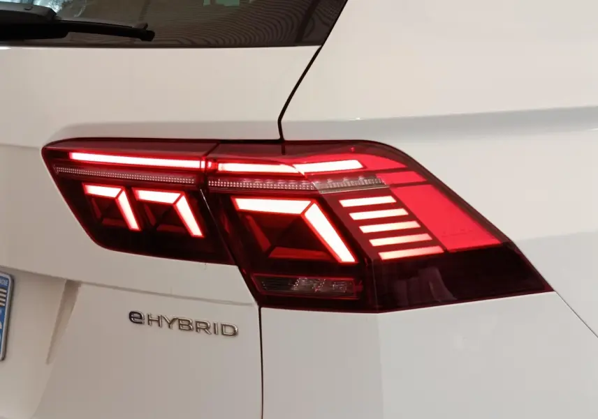 Gros plan sur le feu arrière droit allumé d’un Volkswagen Tiguan blanc eHybrid 2023, avec logo eHYBRID visible.