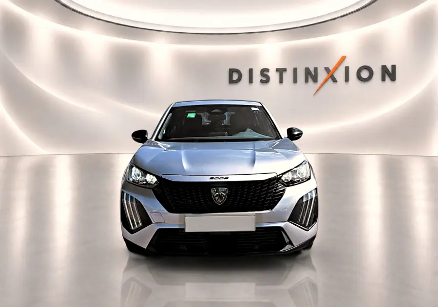 Vue frontale d'un Peugeot 2008 gris avec calandre noire et phares LED, sur fond lumineux avec logo Distinxion.