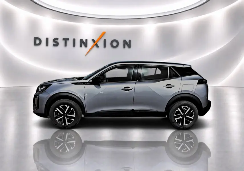 Profil côté gauche d’un Peugeot 2008 gris 2025 avec toit noir et jantes noires à motifs argentés, sur fond blanc lumineux.