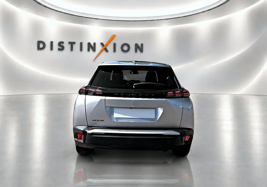 Vue arrière d'un Peugeot 2008 gris 2025 dans un showroom lumineux avec logo Distinxion en arrière-plan.