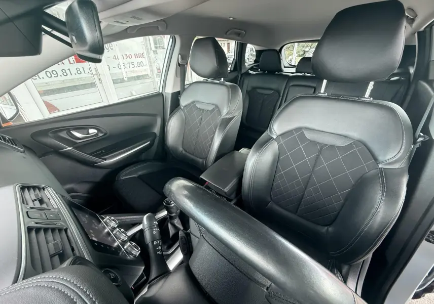 Vue intérieure du Renault Kadjar 2020 montrant les sièges avant en cuir noir avec surpiqûres et console centrale.
