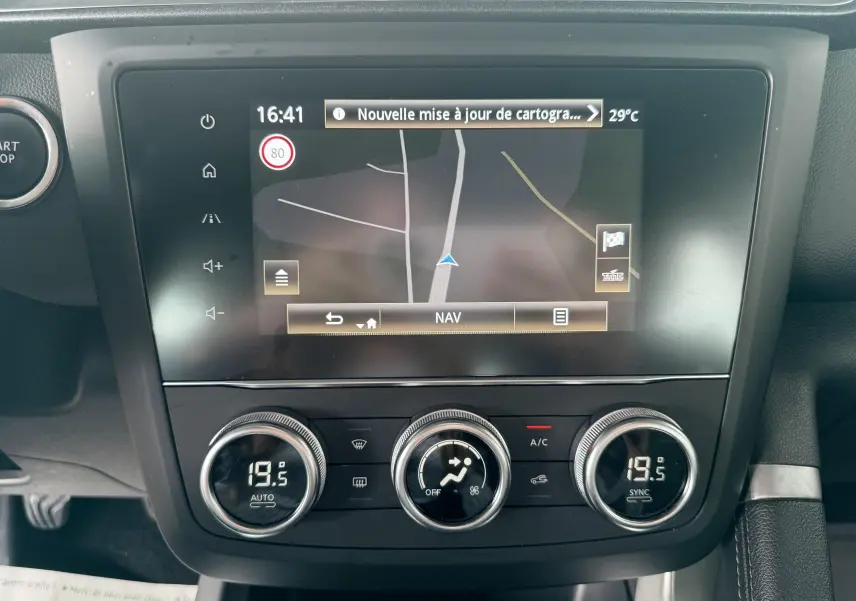 Écran tactile du système de navigation et commandes de climatisation du Renault Kadjar gris, vue frontale intérieure.