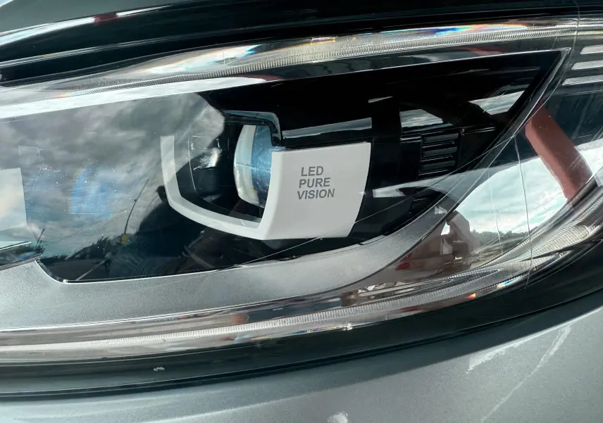 Gros plan sur le phare LED Pure Vision du Renault Kadjar gris, mettant en valeur la technologie d'éclairage avant.