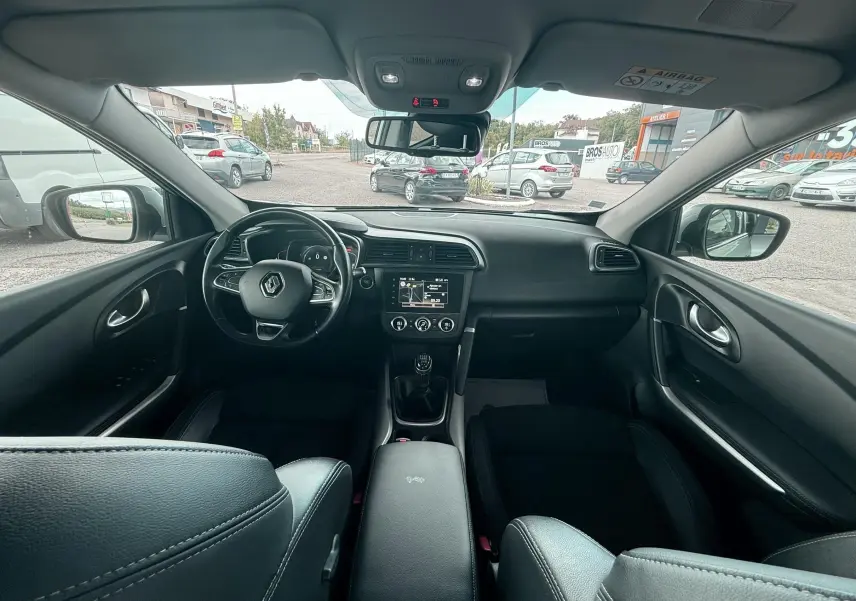 Vue intérieure avant du Renault Kadjar 2020, tableau de bord noir avec volant multifonction et boîte manuelle.