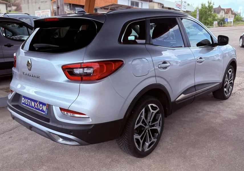 Vue 3/4 arrière droite d'un Renault Kadjar gris avec toit noir et jantes alliage au design moderne.