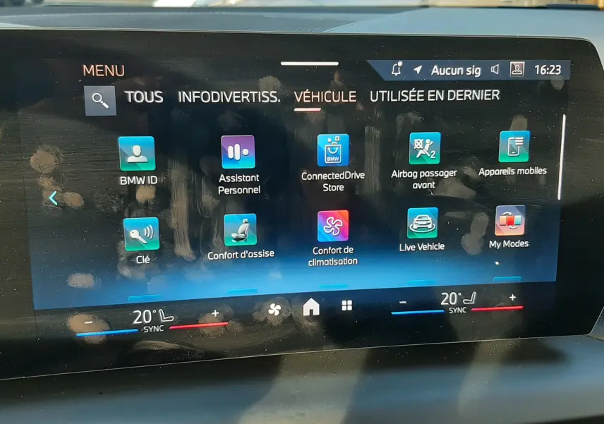 Écran tactile central de la BMW Série 1 2025 affichant les options de confort et connectivité, intérieur noir visible.