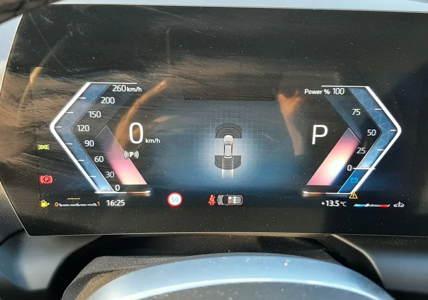 Tableau de bord numérique de BMW Série 1 2025 affichant vitesse, puissance et indicateurs, vue frontale rapprochée.