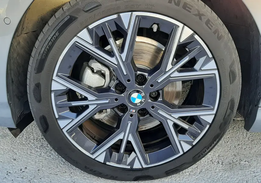 Gros plan sur la jante 18'' bicolore style 975M de la BMW Série 1 gris Skyscraper côté avant droit.