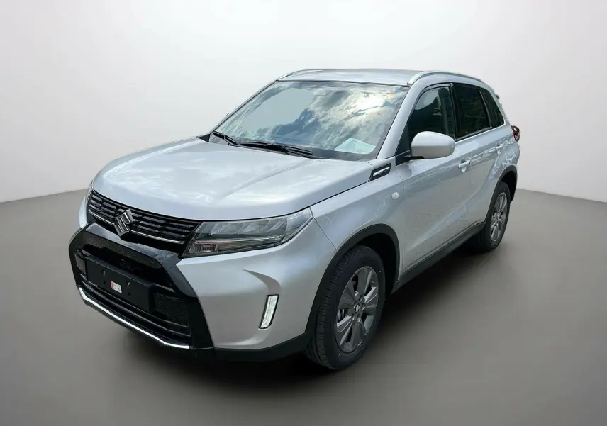 Suzuki Vitara 2025 gris argenté en 3/4 avant droit, avec calandre noire et jantes alu 17 pouces.