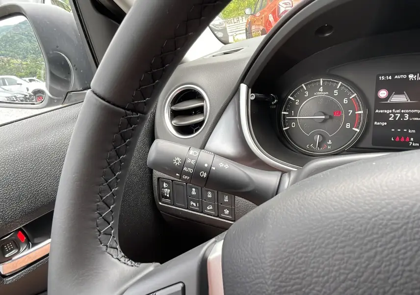 Vue intérieure côté conducteur du Suzuki Vitara 2025 en gris, volant cuir et tableau de bord avec compte-tours et écran multifonction.