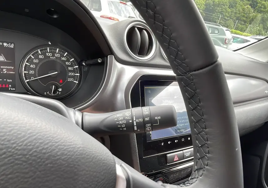Vue intérieure du tableau de bord du Suzuki Vitara 2025, volant cuir multifonctions et écran tactile 9 pouces visible.