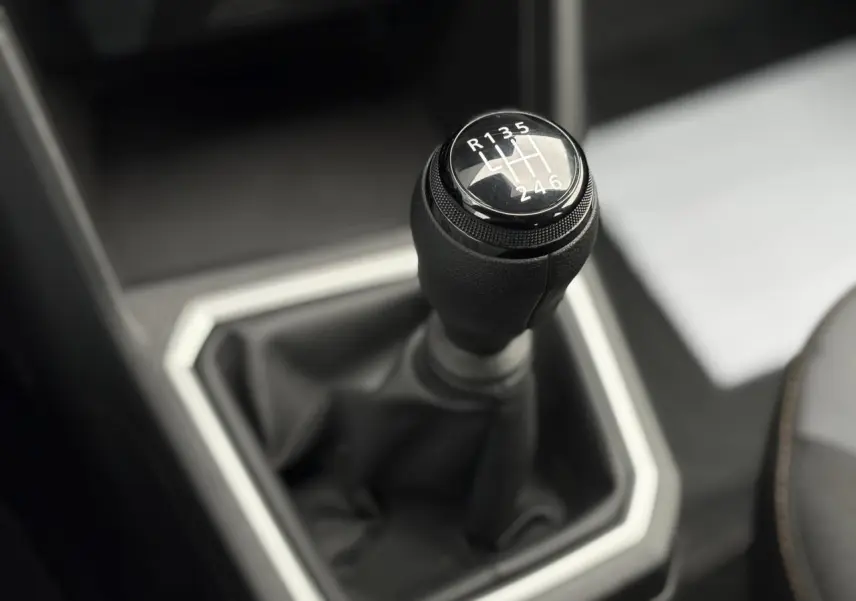 Gros plan sur le levier de vitesses manuel noir de la Dacia Sandero Stepway 2025, intérieur gris et noir.