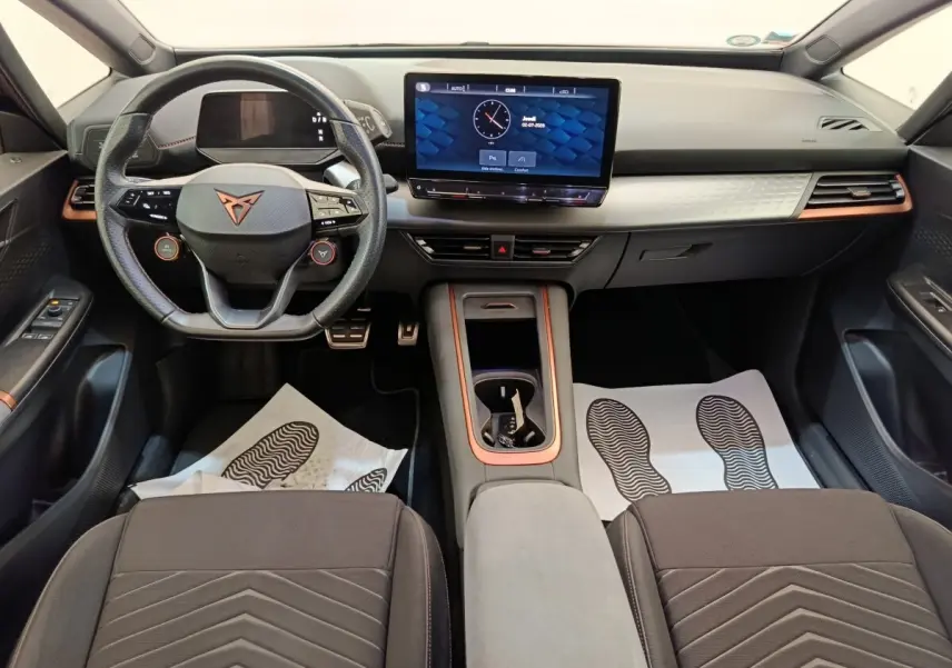Intérieur du CUPRA BORN 230ch 2023 vu de face, volant cuir, écran tactile central et finitions cuivre.