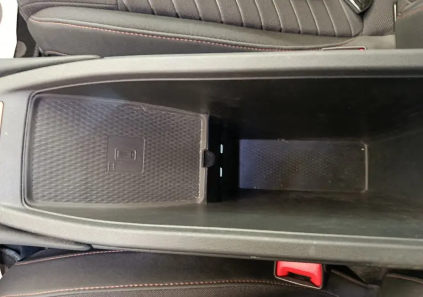Vue rapprochée de la console centrale noire avec chargeur à induction dans la CUPRA BORN gris foncé 2023.