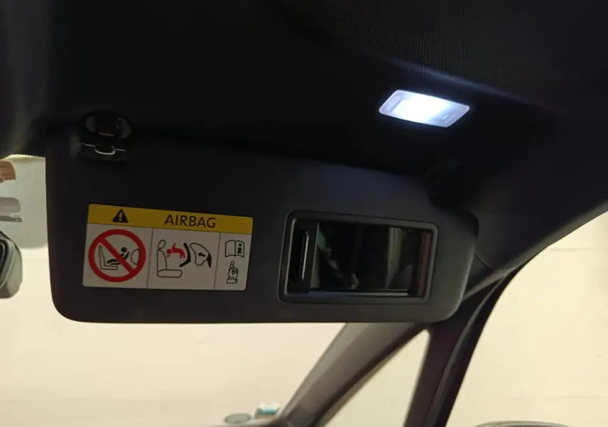 Détail du pare-soleil côté conducteur avec miroir intégré et éclairage intérieur allumé dans un CUPRA Born gris foncé.