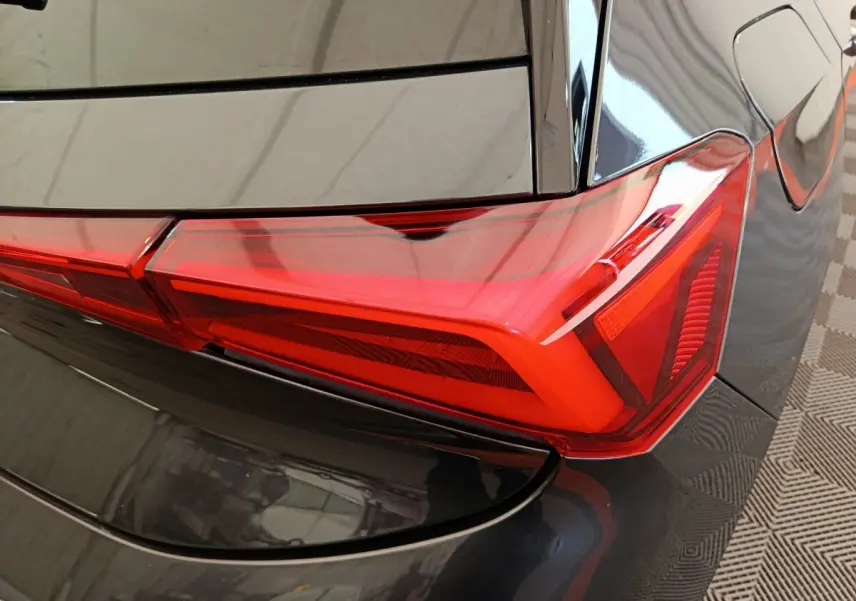 Gros plan sur le feu arrière droit rouge du CUPRA BORN gris foncé, soulignant la finition moderne et les lignes nettes.