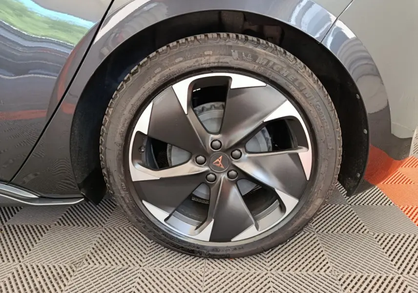 Gros plan sur la roue arrière droite gris foncé d'une CUPRA BORN 230ch avec jante noire et argentée distinctive.