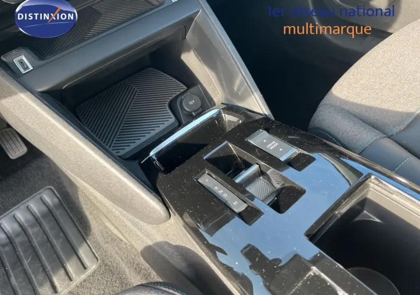 Vue rapprochée de la console centrale noire brillante de la Citroën C4 2023, montrant la commande de boîte automatique et l'espace de rangement.
