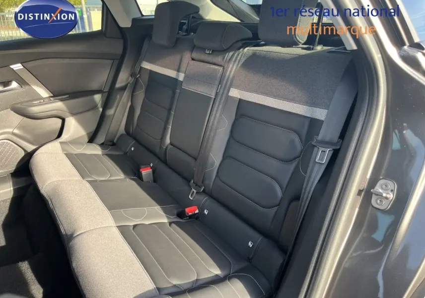 Vue intérieure de la banquette arrière bicolore gris et noir du Citroën C4 2023, avec ceinture et porte ouvert côté droit.