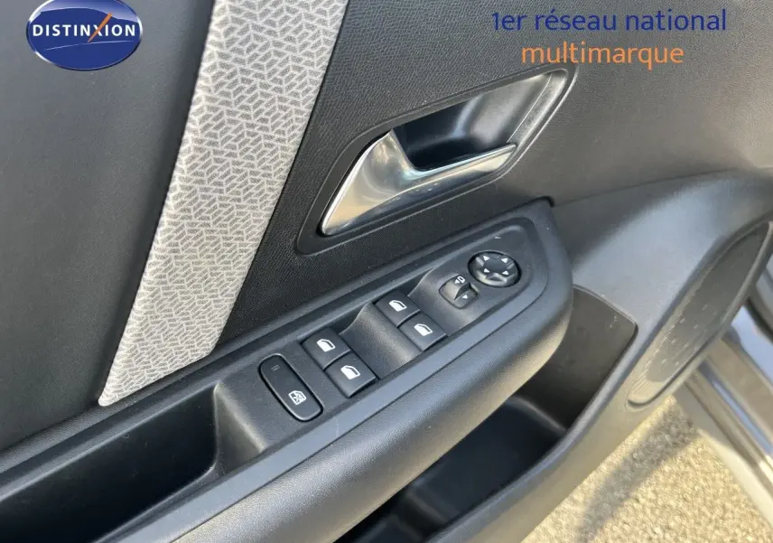 Gros plan sur la porte côté conducteur de la Citroën C4 gris 2023, montrant les commandes des vitres et le bouton de réglage des rétroviseurs.