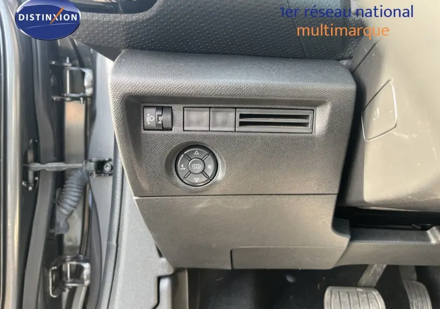 Détail intérieur côté gauche du tableau de bord gris d'une Citroën C4 2023 avec commandes d'éclairage et ventilation.