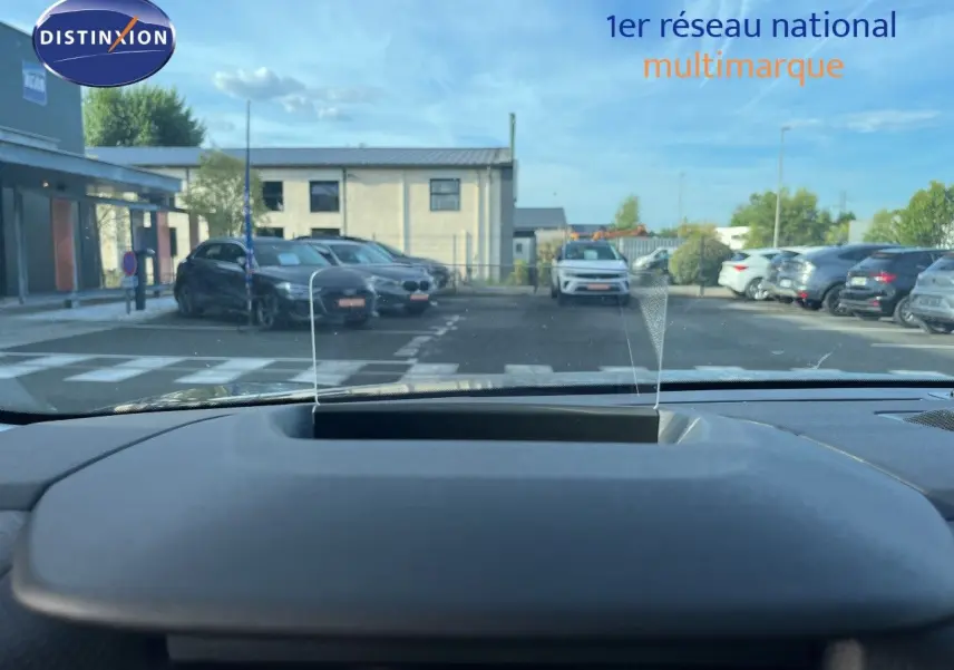 Vue depuis l'habitacle du Citroën C4 gris 2023, montrant le tableau de bord et le pare-brise avec affichage tête haute.
