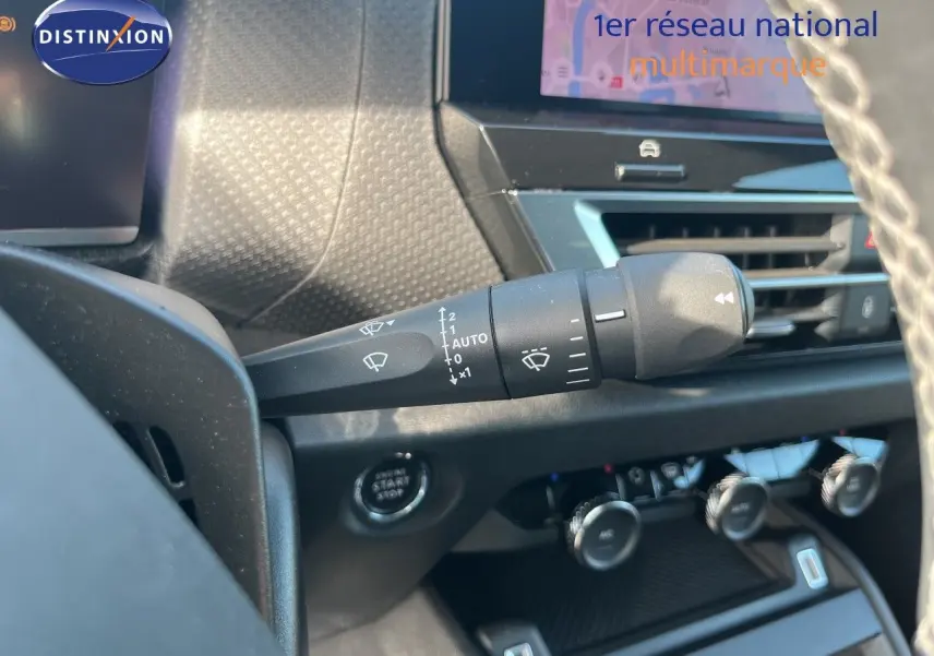 Gros plan sur la commande d’essuie-glace à gauche du volant dans l’habitacle gris d’une Citroën C4 2023.