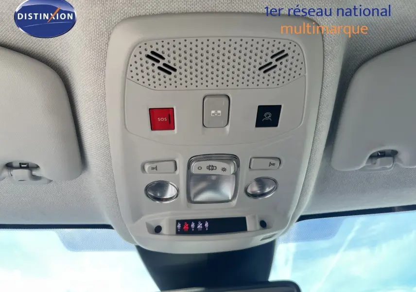 Vue intérieure du plafonnier de la Citroën C4 2023 gris, montrant les commandes d'éclairage et le bouton SOS.