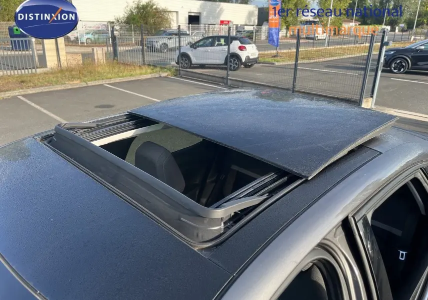 Toit ouvrant panoramique ouvert sur le dessus d'une Citroën C4 gris 3/4 arrière en extérieur.