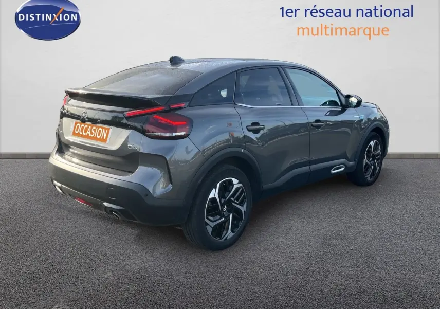 Vue 3/4 arrière droite d'une Citroën C4 gris métallisé 2023 avec feux arrière LED et jantes alliage noires.