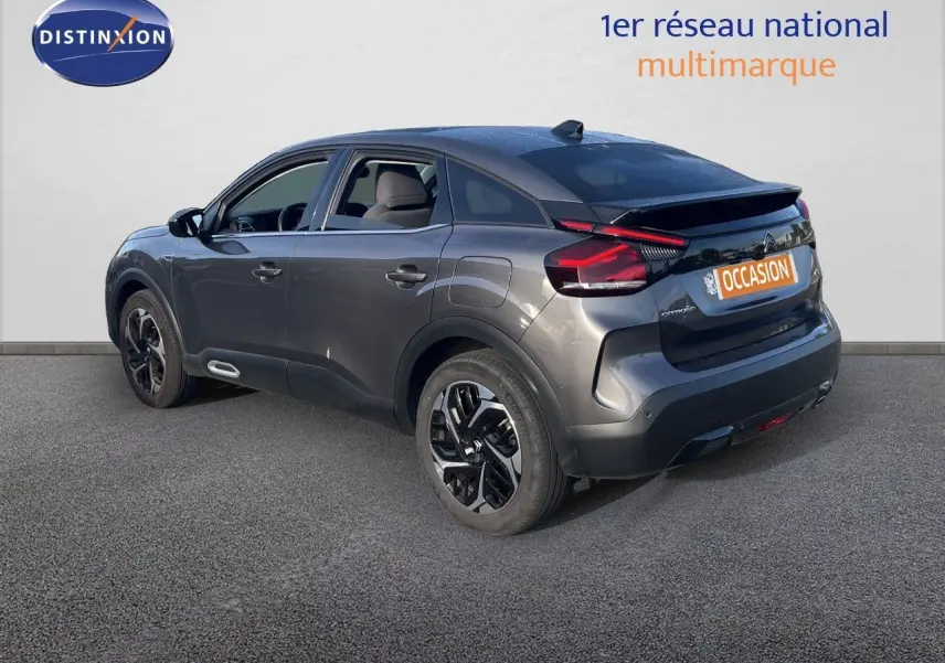 Citroën C4 gris en 3/4 arrière droit, mettant en valeur ses feux arrière LED et ses jantes noires bicolores.