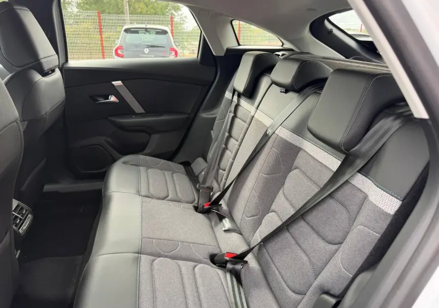 Vue intérieure côté droit de la banquette arrière gris tissu et cuir du Citroën C4 électrique blanc 2024.