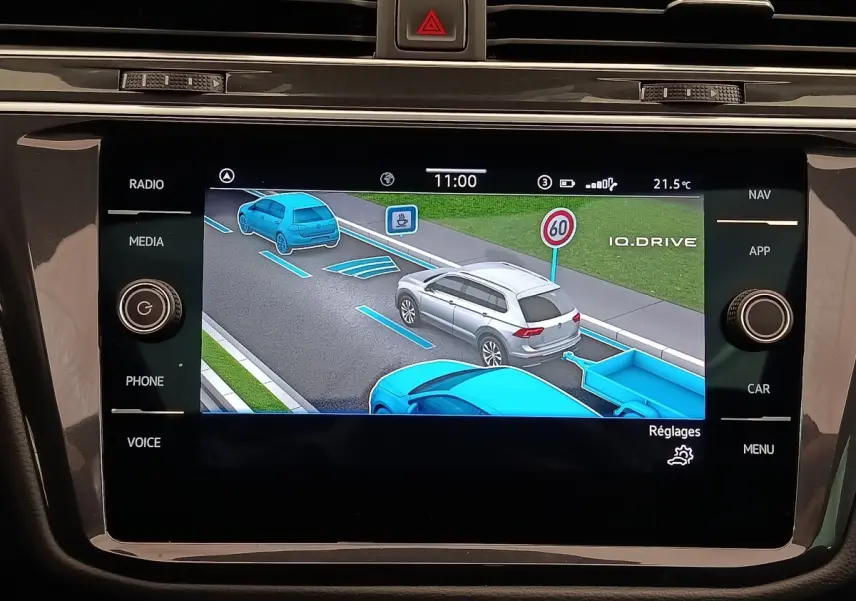 Écran tactile du tableau de bord montrant l’aide au stationnement avec représentation graphique d’un SUV gris en vue arrière.
