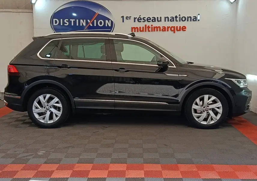 Volkswagen Tiguan 2.0 TDI 150 DSG7 Elegance noir vu de profil côté gauche en intérieur showroom.