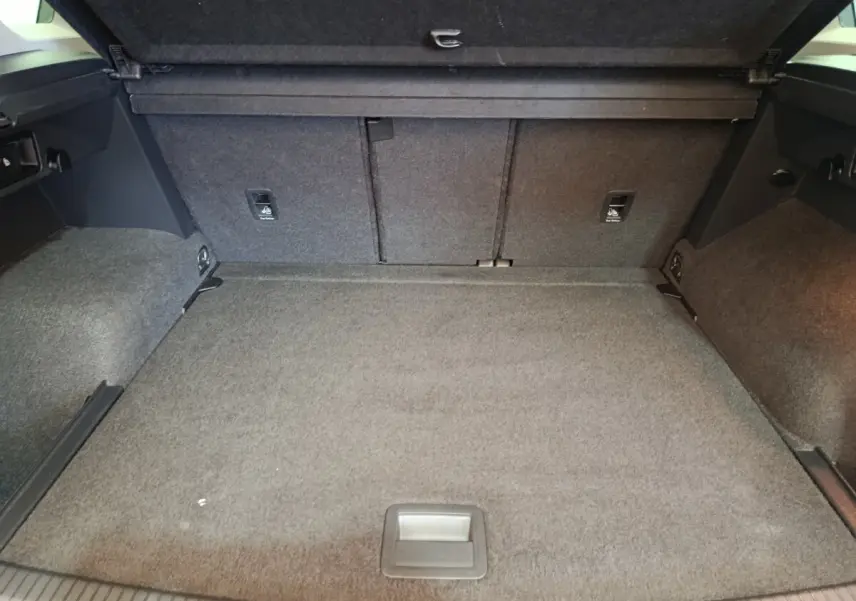 Coffre spacieux du Volkswagen Tiguan 2.0 TDI 150 DSG7 Elegance, vue intérieure arrière avec revêtement gris.