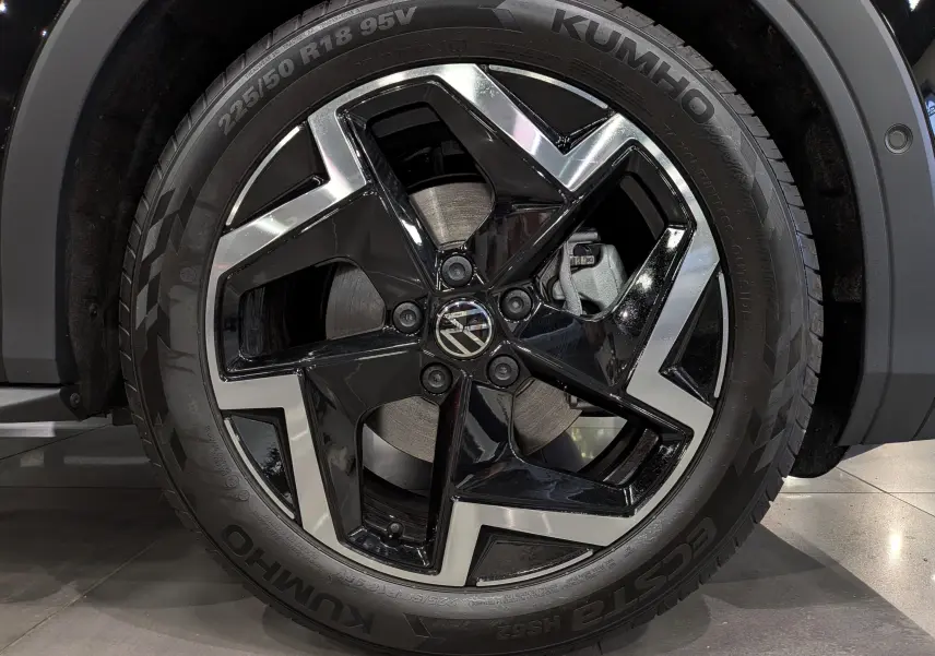 Gros plan sur la jante bi-ton noire et argent du Volkswagen T-Roc eTSI 150 CH DSG7 R-LINE 2026 en noir Ébène.